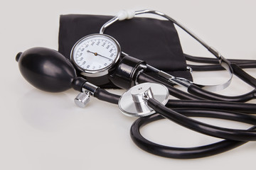 Close up view of black stethoscope and sphygmomanometer isolated on white background. Sphygmomanometer and stethoscope kit is used to measure blood pressure. Healthcare and medicine concept. 