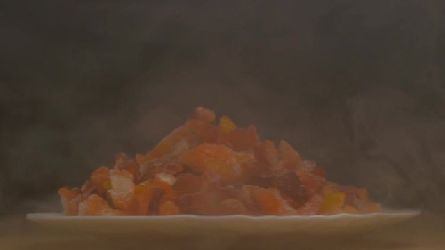 Plate with sliced frozen peppers, which rotates and blows cold, freshness and haze, close-up, slow motion, vegetarian