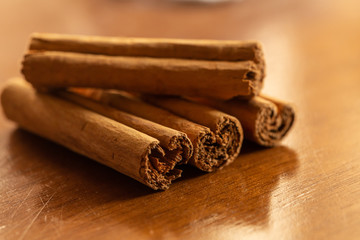 Close up of cinnamon's pieces on wood background