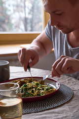Man cutting chicken meat in a plate