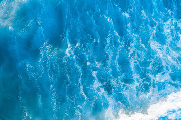 Obraz premium Looking down at beautiful blue ocean water and wave. Aerial view with copy space.
