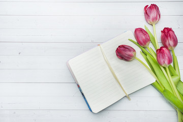 Overhead view of a bouquet of tulips and notebook. copy space. Flat lay, top view