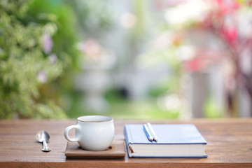 White cup with diary notebook at outdoor