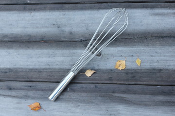 A whisk on a wooden table