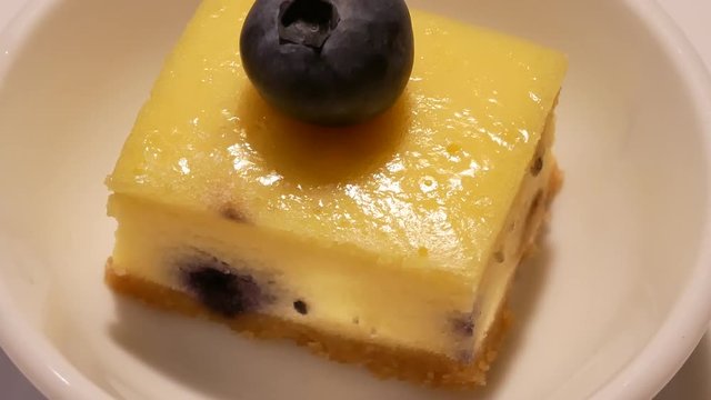 Rotating of mango mousse mini cake on table inside restaurant with 4k resolution.