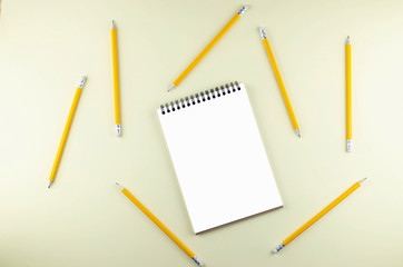 Isolated notepad with a lot of simple pencils on a yellow background.