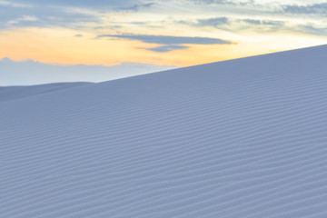 Sand ripples on white dune at sunset