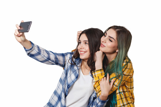 Two girls friends taking selfie with smartphone, isolated on white background
