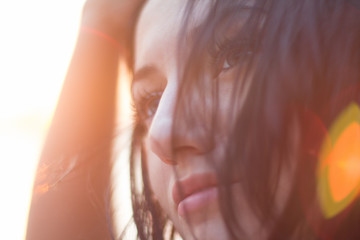 Closeup portrait of young woman in bright light of sunset. Summer