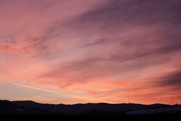 Beautiful colorful sunset over Banska Bystrica, Slovakia. Winter snowy valley and dramatic sky.