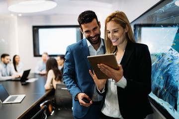 Businesspeople discussing while using digital tablet in office