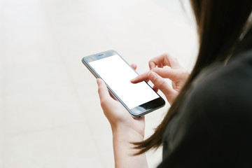 Girl holding smartphone with white empty screen. Closeup female finger pointing on screen modern phone. 