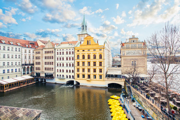 View from Charles Bridge and Old Town Bridge Tower on Vltava river, cloudy sky and yellow boats, Prague, Czech Republic