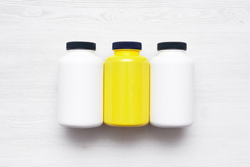 Sport nutrition jars on a white wooden table background.