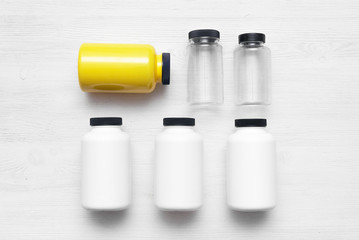 Sport nutrition jars on a white wooden table background.