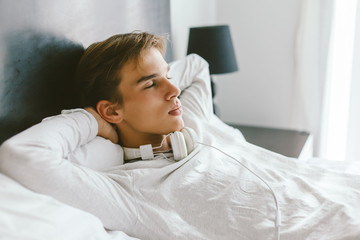 16 years old teenager relaxing on bed in his room