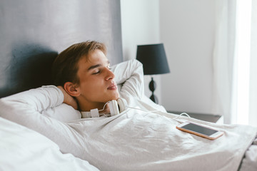 16 years old teenager relaxing on bed in his room