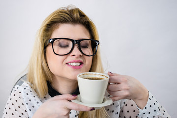 Happy woman at office drinking hot coffee