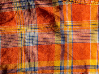 Orange and yellow plaid print as background. Symmetric rhombus pattern.