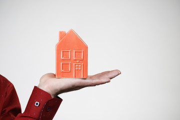 Man holding red house model
