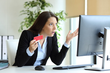 Confused office worker trying to pay online with credit card