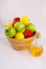 Fresh apples in a wooden vase. Green, yellow and red apples isolated on white