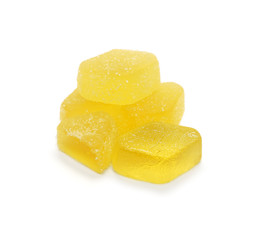 Marmalade pieces bright yellow sprinkled with sugar isolated on a white background.