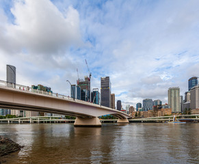 Fototapeta na wymiar Bridge across Brisbane river and high-rise buildings on bright summer day