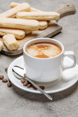 Italian Savoiardi ladyfingers Biscuits and cup of coffee on concrete backgound