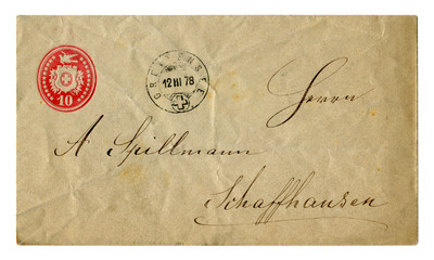 Old crumpled Swiss envelope with red stamp and postmark December 1878, with handwritten text in black ink, calligraphy.