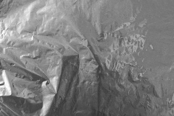 Crumpled silver aluminum foil background, abstract texture