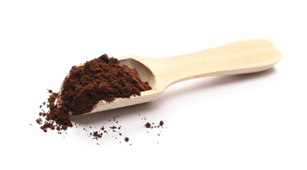 Milled coffee powder with wooden spoon isolated on white background
