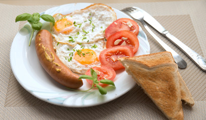 food breakfast fried eggs with sausage tomatoes basil and garlic on the table