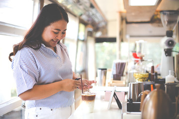 Woman holding plastic glass of iced coffee with milk on cafe background, Selective Focus.