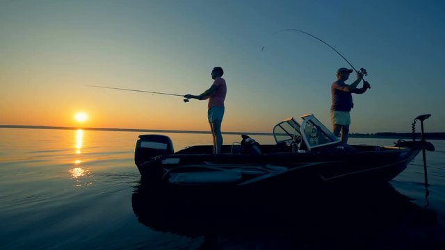 Fishermen catch fish in the evening, using special rods. 4K