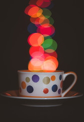 Teacup with bokeh coming from the cup on a black background 