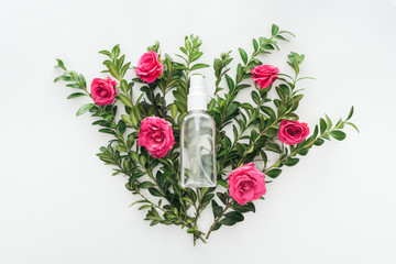 top view of empty spray bottle on flowers composition on white background