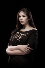portrait of young brunette girl with black tears from eyes and lace pattern on face and neck posing...