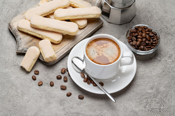 Italian Savoiardi ladyfingers Biscuits and cup of coffee on concrete backgound