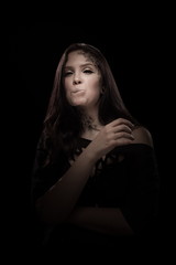 portrait of young brunette girl with black tears from eyes and lace pattern on face and neck posing...