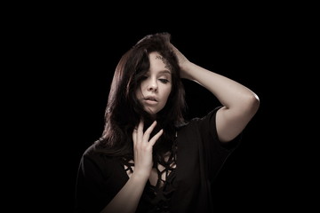 portrait of young brunette girl with black tears from eyes and lace pattern on face and neck posing...