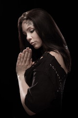 portrait of young brunette girl with black tears from eyes and lace pattern on face and neck posing...