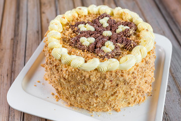 Cake delicious on plate. Bakery, cream dessert cake with tea spot on wooden table