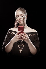 young brunette girl with black tears from her eyes makes selfie, talks and writes by phone