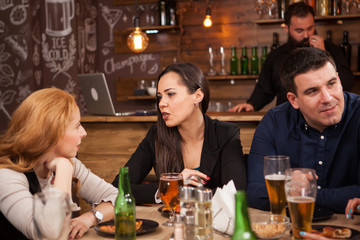 Friends in the pub drinking beer talking and having fun