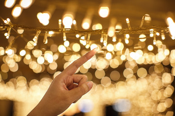 woman hand holding string vintage LED christmas lights with blurred and bokeh background