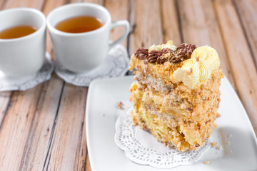 Cake delicious on plate. Bakery, cream dessert cake with tea spot on wooden table