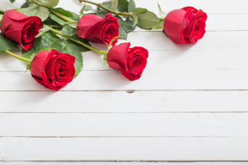  red roses on white wooden background