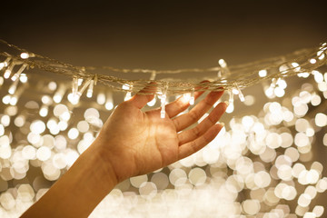 woman hand holding string vintage LED christmas lights with blurred and bokeh background