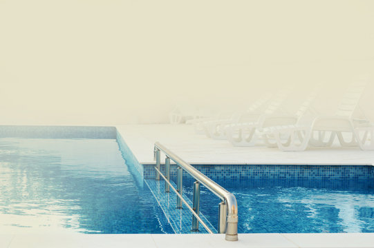 blue water pool ready to use on a warm misty summer morning with space for text